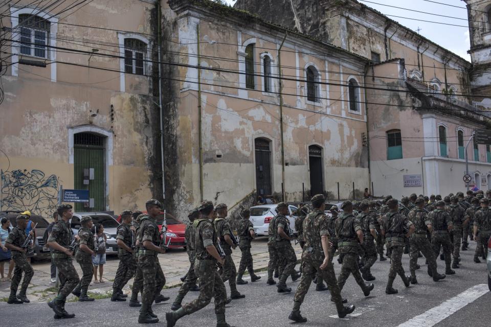 In this Sept. 7, 2019 photo, military police parade near the Ver-o-Peso riverside market in Belém, Brazil. The city is the capital and largest city of the state of Pará and is the gateway to the Amazon River with a busy port, airport, and bus/coach station. (AP Photo/Rodrigo Abd)