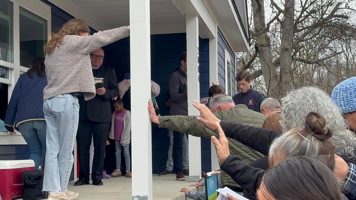 Habitat for Humanity members and Columbia members bless the Bettis' new home