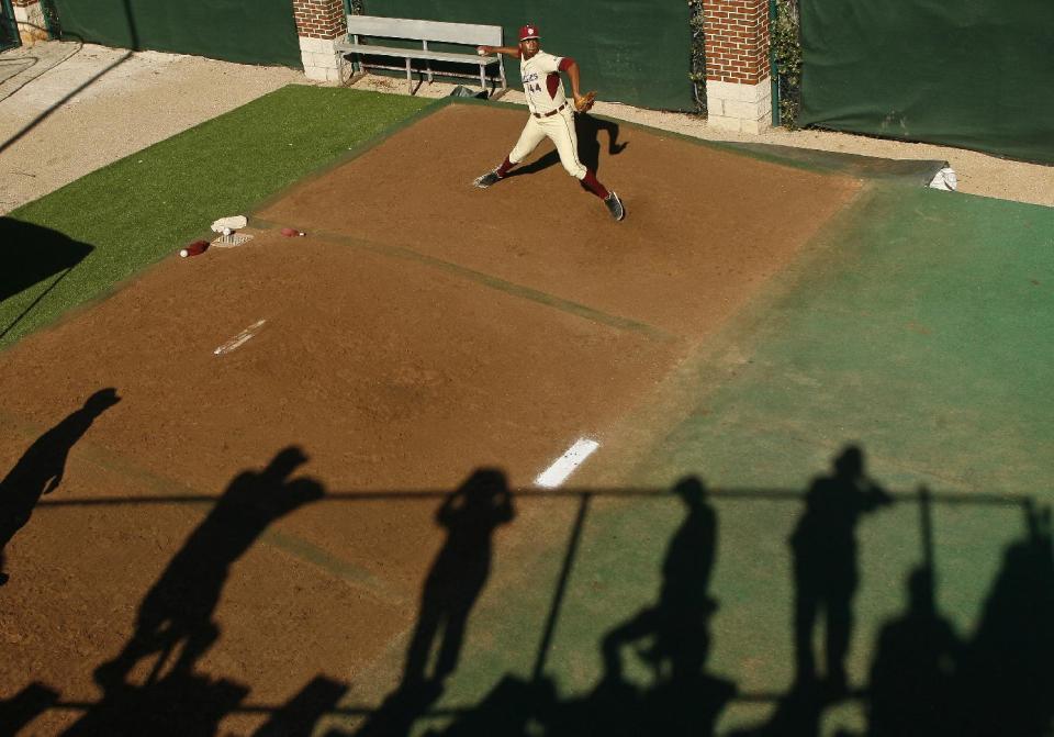 Florida State fans cast shadows as they watch relief pitcher Jameis Winston (44) warm up in the bullpen in the eighth inning of an NCAA college baseball game against Miami on Sunday, March 2, 2014, in Tallahassee, Fla. Florida State won 13-6. (AP Photo/Phil Sears)