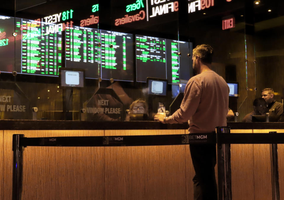 FILE - A customer makes a sports bet at the Borgata casino in Atlantic City N.J. on March 17, 2022 just before the March Madness NCAA college basketball tournament began. As March Madness gets underway, more people than ever now can legally bet on sports. A total of 38 states and the District of Columbia now allow some form of sports betting. (AP Photo/Wayne Parry, File)