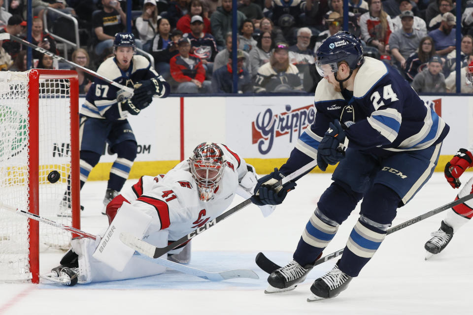 Carolina Hurricanes' Spencer Martin, left, makes a save against Columbus Blue Jackets' Mathieu Olivier during the second period of an NHL hockey game Tuesday, April 16, 2024, in Columbus, Ohio. (AP Photo/Jay LaPrete)