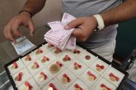 A gold dealer counts Turkish lira banknotes, in Istanbul