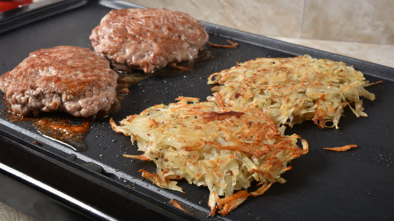 Sausages and hash browns on electric griddle