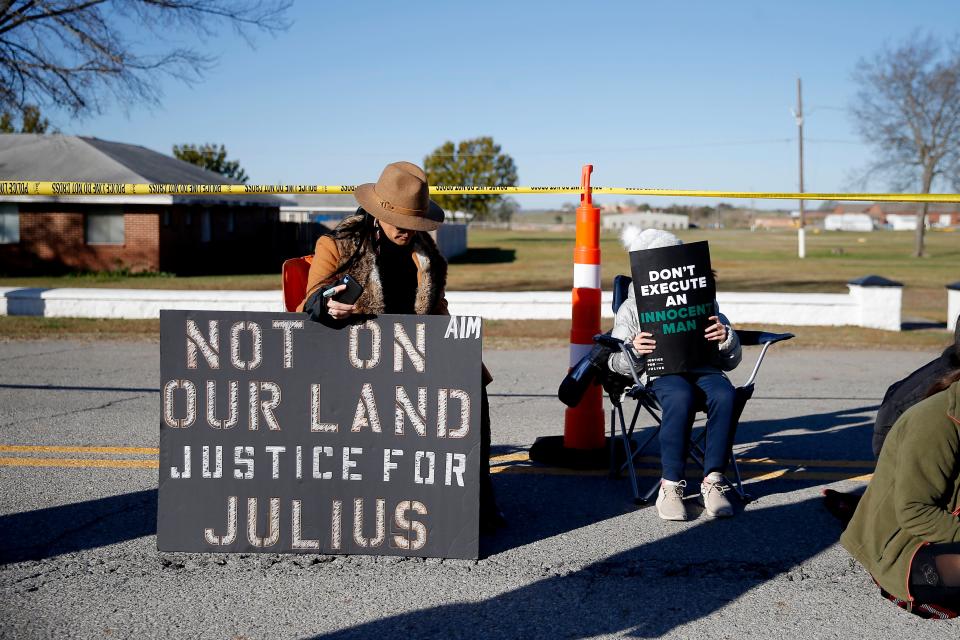 Julius Jones supporters hold signs in support of the death row inmate outside the Oklahoma State Penitentiary in McAlester, Okla., Thursday, Nov. 18, 2021. Supporters of Jones gathered outside the penitentiary before his scheduled execution. 