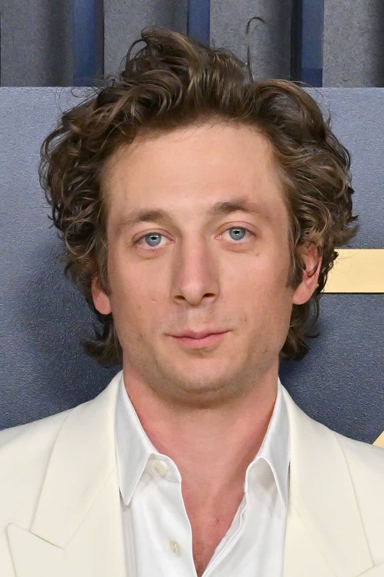 Jeremy Allen White, with tousled blonde hair, posing on red carpet