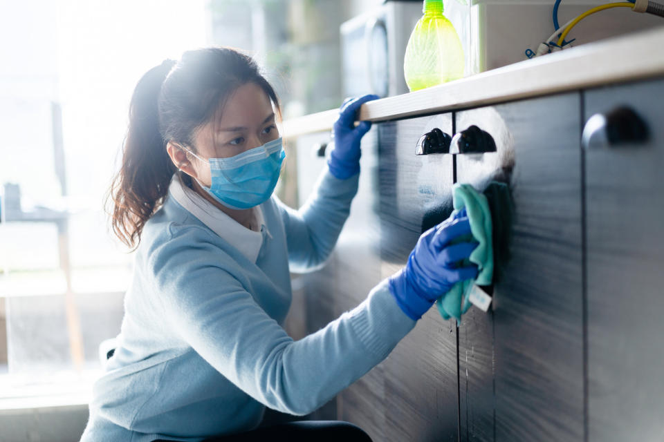 person cleaning a cabinet