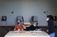 Election judges Andrew Olson, left, and Sandra Hunter, show voter Riya Madan where to cast her ballot inside the Frederick R. Weisman Art Museum at the University of Minnesota in Minneapolis on Tuesday, Aug. 11 2020. (Anthony Souffle/Star Tribune via AP)