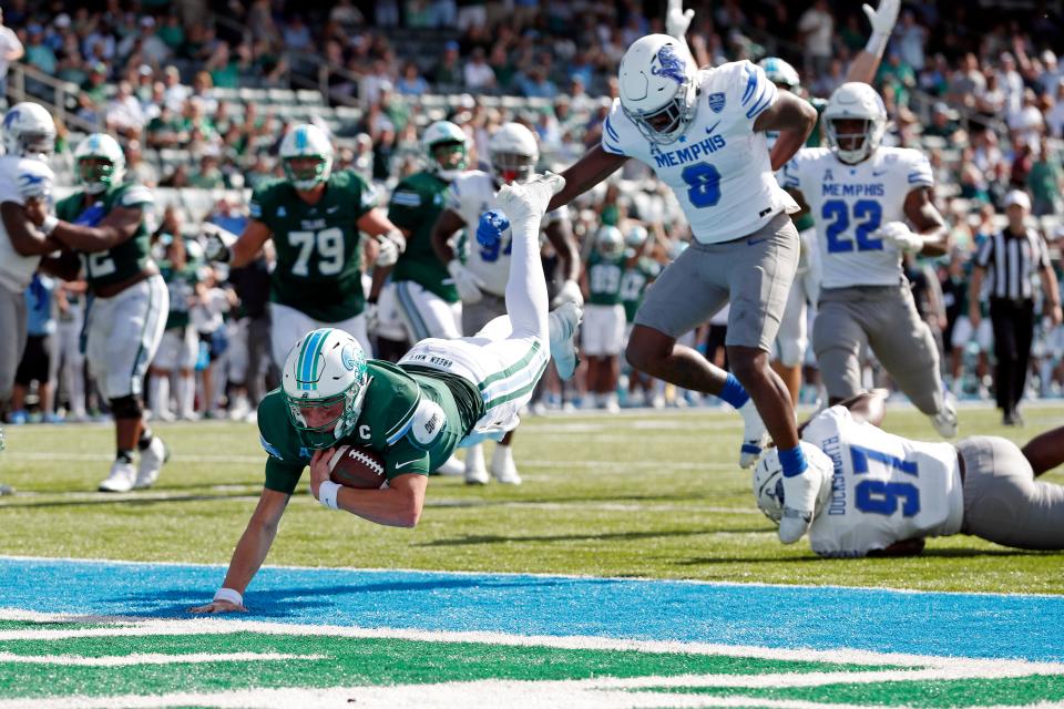 Tulane quarterback Michael Pratt (7) dives in the end zone past Memphis linebacker Xavier Cullens (8) to score a touchdown during the first half of an NCAA college football in New Orleans,  Saturday, Oct. 22, 2022. (AP Photo/Tyler Kaufman)