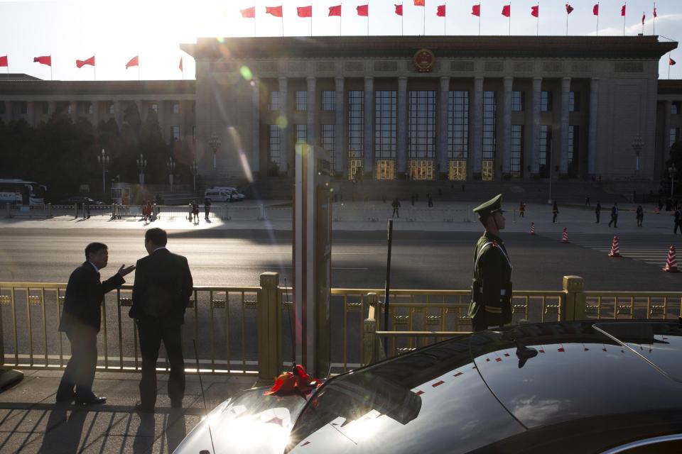 CHANGING SLUG - In this Wednesday, March 8, 2017 photo, two Chinese men chat in front of the Great Hall of the People in Beijing where China's top leaders gathered a plenary session of the National People's Congress in Beijing. While the Great Hall of the People buzzes with activity during state events, especially the roughly two-weeks of the legislative session, at other times the hall is strangely quiet, with voices echoing off its marble walls and sentinels standing silently in its forecourt that looks out onto the vast expanse of Tiananmen Square. (AP Photo/Ng Han Guan)