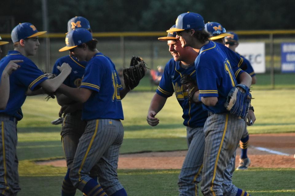 Dawson Glassco wraps his arm around teammate Ben Seitzinger after the first baseman saved him from committing a throwing error with a nice pick against Linton.