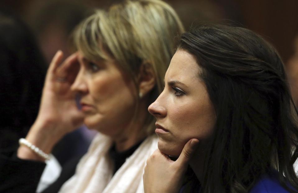 Aimee Pistorius, right, sister of Oscar Pistorius, listens in the public gallery, as state prosecutor Gerrie Nel questions Pistorius in court in Pretoria, South Africa, Friday, April 11, 2014. The prosecutor at Oscar Pistorius' murder trial on Friday challenged the athlete's statements that he was worried about crime before he fatally shot girlfriend Reeva Steenkamp through a closed toilet door in his home. Pistorius has said he killed Steenkamp by accident after mistaking her for an intruder in the early hours of Feb. 14, 2013. (AP Photo/Themba Hadebe, Pool)