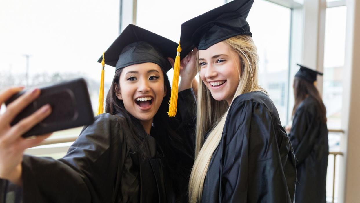 high school grads take selfie after their graduation ceremony