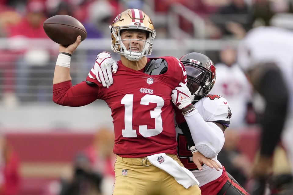 FILE - San Francisco 49ers quarterback Brock Purdy (13) passes as Tampa Bay Buccaneers linebacker Devin White applies pressure during the first half of an NFL football game in Santa Clara, Calif., Sunday, Dec. 11, 2022. This season revealed, like never before, a glaring amount of instability at quarterback in the NFL, whether because of injury — the reason for nearly half of all changes during the regular season, according to an AP analysis — or poor performance.(AP Photo/Tony Avelar, File)