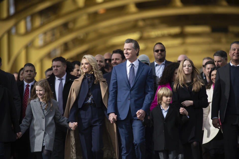 CORRECTS SPELLING OF SURNAME TO NEWSOM - Governor Gavin Newsom with his wife Jennifer Siebel Newsom walk with their children and children Brooklynn, left, Dutch, and Montana as they walk across the Tower Bridge in Old Sacramento before the Inauguration of Governor Gavin Newsom in Sacramento, Calif., Friday, Jan. 6, 2023. (AP Photo/José Luis Villegas)