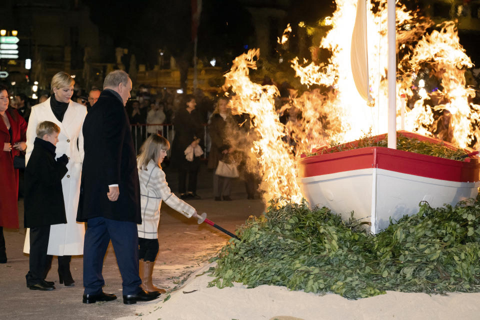 À l'aide de torches, la famille princière enflamme la barque à la Sainte-Dévote