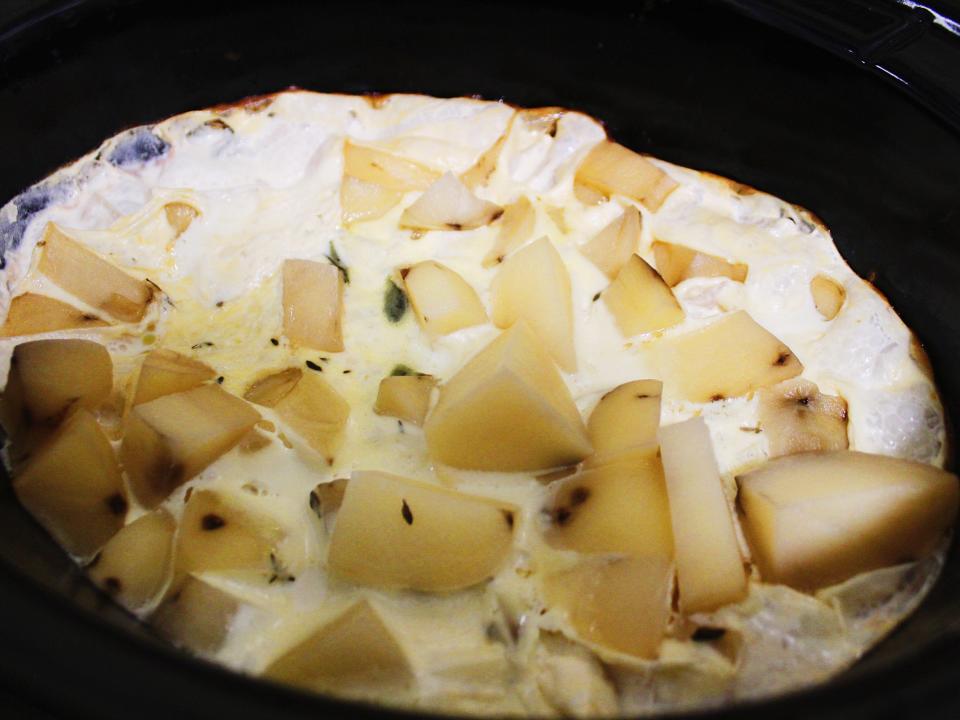 cooked chopped potatoes, herbs, and cream in slow cooker