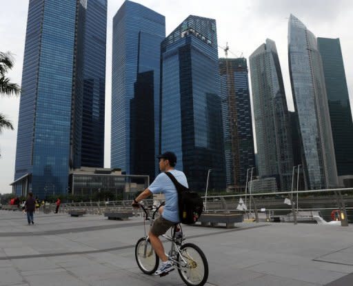 A man rides a bicycle along a promenade in front of Marina Bay financial centre in Singapore in July 2012. Singapore's economy shrank 0.7 percent in the second quarter, the government said Friday, although the decline was at a slower pace than expected