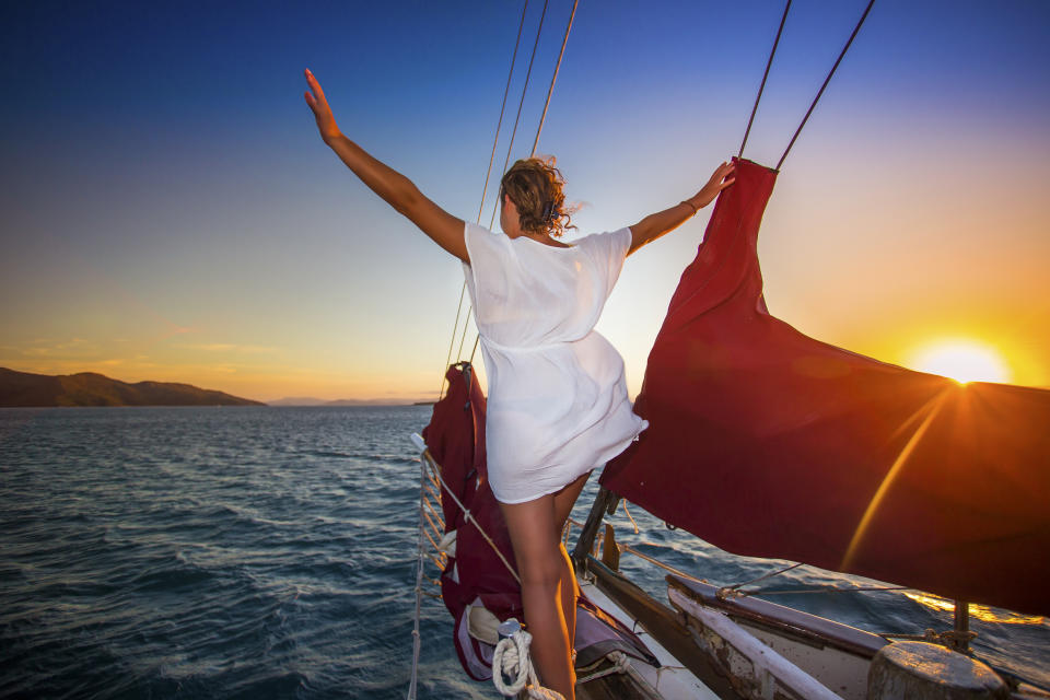 Sailing through the Whitsunday Islands is one of the most popular attractions in Australia. Passengers sit and watch the sunset descend over the ocean.