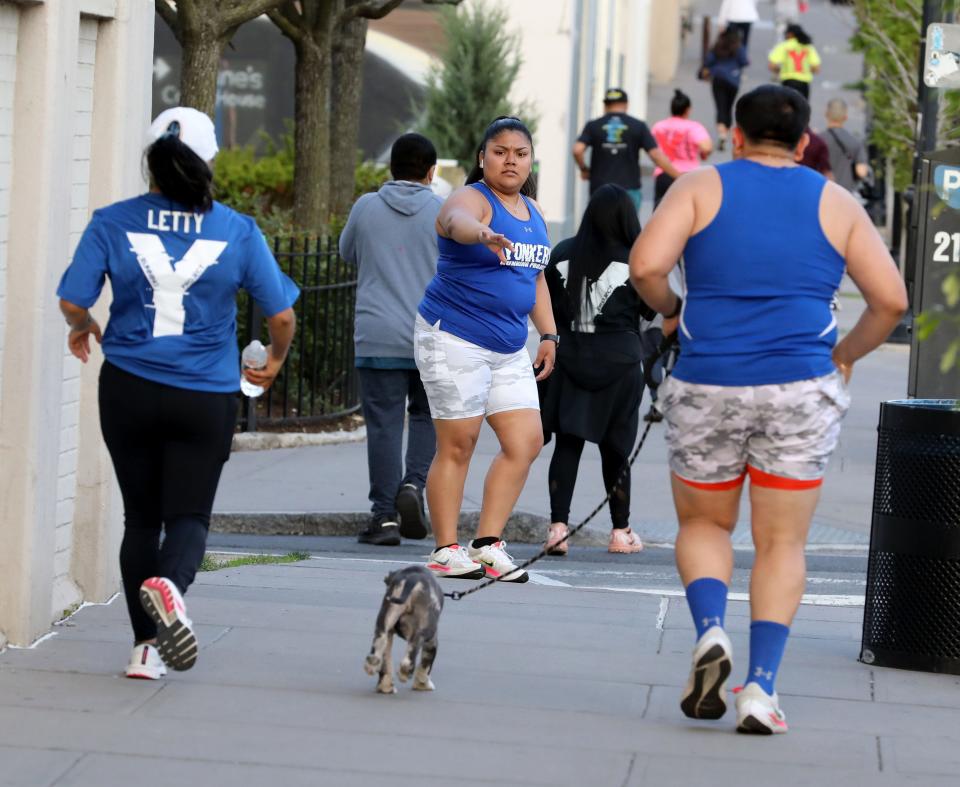 A group of runners and their family dog, run along Dock Street in Yonkers during the weekly Yonkers Running Project run, May 11, 2022. 