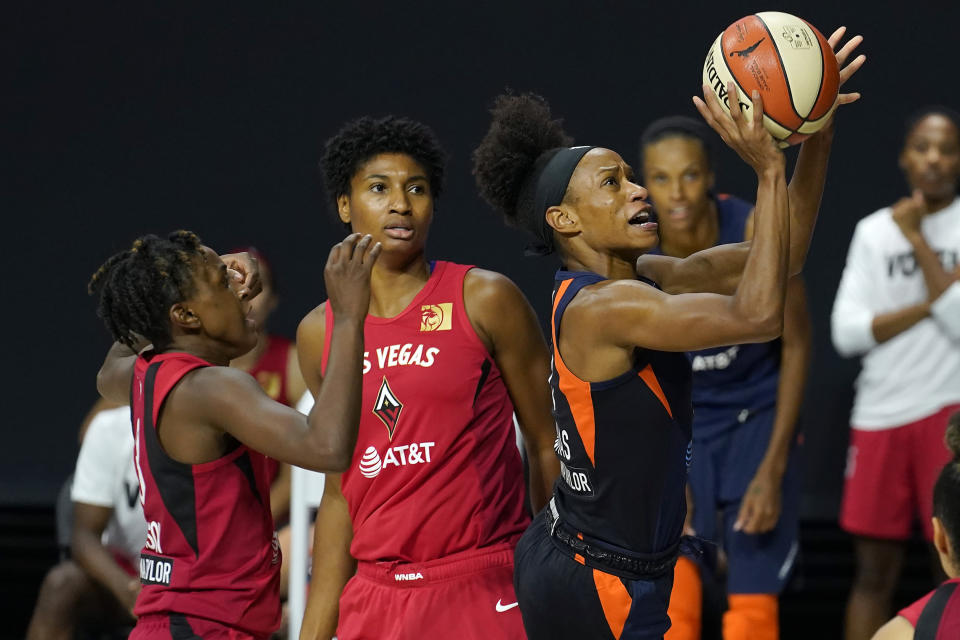 Connecticut Sun guard Jasmine Thomas (5) shoots after driving past Las Vegas Aces guard Danielle Robinson (3) and forward Angel McCoughtry (35) during the second half of Game 3 of a WNBA basketball semifinal round playoff series Thursday, Sept. 24, 2020, in Bradenton, Fla. (AP Photo/Chris O'Meara)