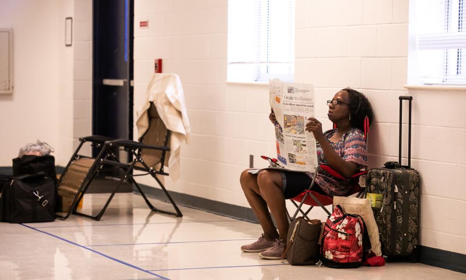 Debra Johnson of Ocala reading the newspaper Tuesday at Vanguard High School's hurricane shelter.