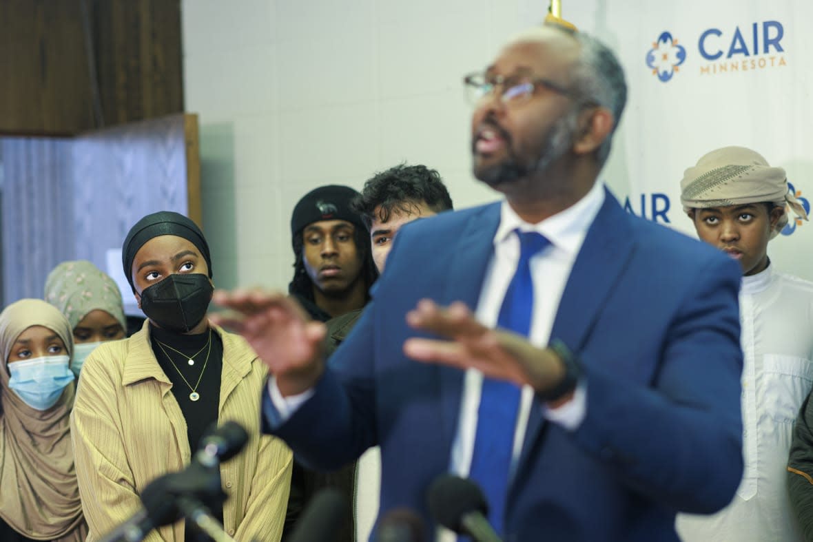 Aram Wedatalla, left, a Hamline University senior and the president of Muslim Student Association (MSA), listens as Jaylani Hussein, executive director of the Minnesota chapter of the Council on American-Islamic Relations, speaks during a news conference at CAIR-MN office, Wednesday, Jan. 11, 2023, in Minneapolis. (Kerem Yücel/Minnesota Public Radio via AP)