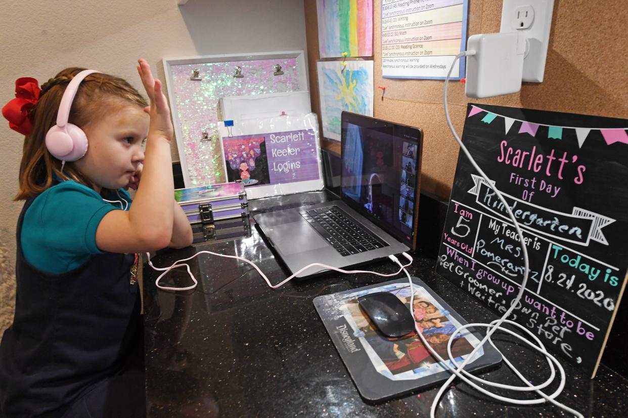 Doral Academy Red Rock Elementary School kindergartener Scarlett Keeler, 5, raises her hand as she takes an online reading and science class on her first day of distance learning amid the spread of the coronavirus on Aug. 24, 2020 in Las Vegas, Nevada.