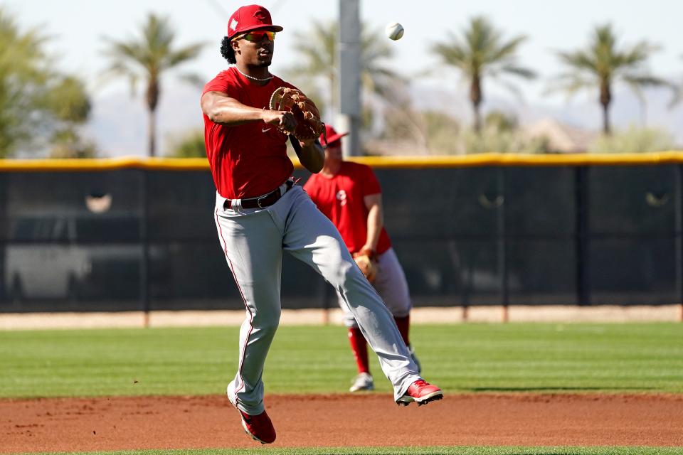 Cincinnati Reds infielder throws to first base Jose Barrero (2) during infield drills, Tuesday, March 15, 2022, at the baseball team's spring training facility in Goodyear, Ariz.