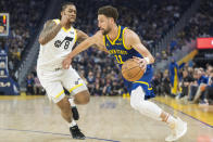 Golden State Warriors guard Klay Thompson (11) drives the ball past Utah Jazz forward Brice Sensabaugh (8) during the first half of an NBA basketball, game Sunday, April 7, 2024, in San Francisco. (AP Photo/Nic Coury)