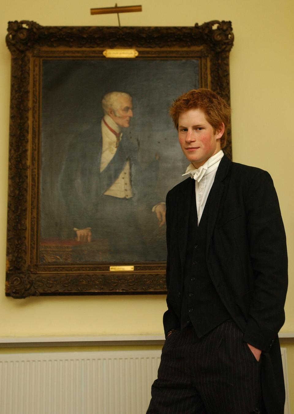 Prince Harry, wearing a school uniform, poses by a portrait of the Duke of Wellington at the Manor House, Eton College, on May 12, 2003.