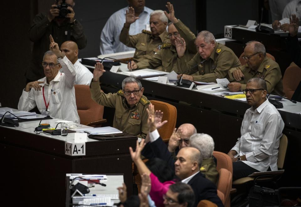 El primer secretario del Partido Comunista y expresidente Raúl Castro, centro izquierda, levanta la mano para aprobar la agenda antes de una sesión de la Asamblea Nacional del Poder Popular en La Habana, Cuba, el viernes 20 de diciembre de 2019. (AP Foto / Ramón Espinosa)