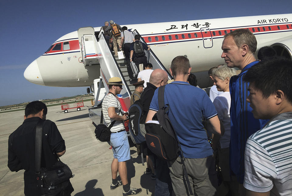 FILE - Passengers board an Air Koryo plane at the Pyongyang International Airport in Pyongyang, North Korea, on June 27, 2015. Russian tourists going on a ski trip will be the first international travelers to visit North Korea since the country's borders closed in 2020 amid the global pandemic lockdown, according to a report on the Russian state-run Tass news agency. (AP Photo/Wong Maye-E, File)