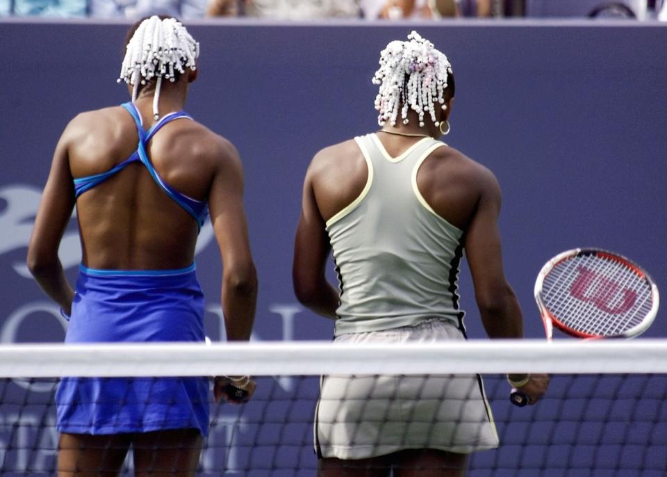 Venus (left) and Serena Wiliams talk strategy during a match at the U.S. Open in Flushing Meadows, New York, on Sept. 2, 1999. (Photo: TIMOTHY A. CLARY/AFP via Getty Images)