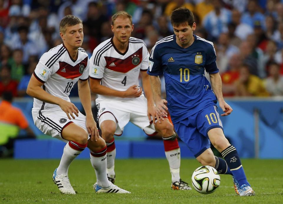 Argentina's Lionel Messi (R) fights for the ball with Germany's Toni Kroos (L) and Benedikt Hoewedes during their 2014 World Cup final at the Maracana stadium in Rio de Janeiro July 13, 2014. REUTERS/Damir Sagolj (BRAZIL - Tags: SOCCER SPORT WORLD CUP)