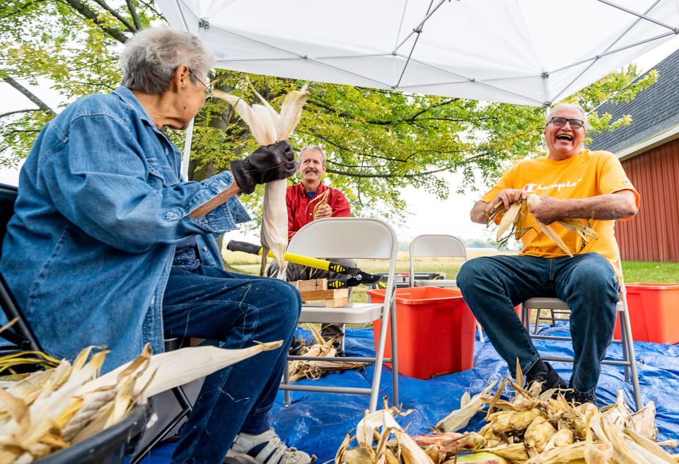 Left to right, Carol Elm of Oneida, Frank Kutka of Door County, and Randy Cornelius, an Oneida community member, husk corn at the Yeyathókwas Wahnitale (Harvest Moon), a multigenerational event hosted by the the Oneida white corn co-op Ohe·láku (Among the Cornstalks).