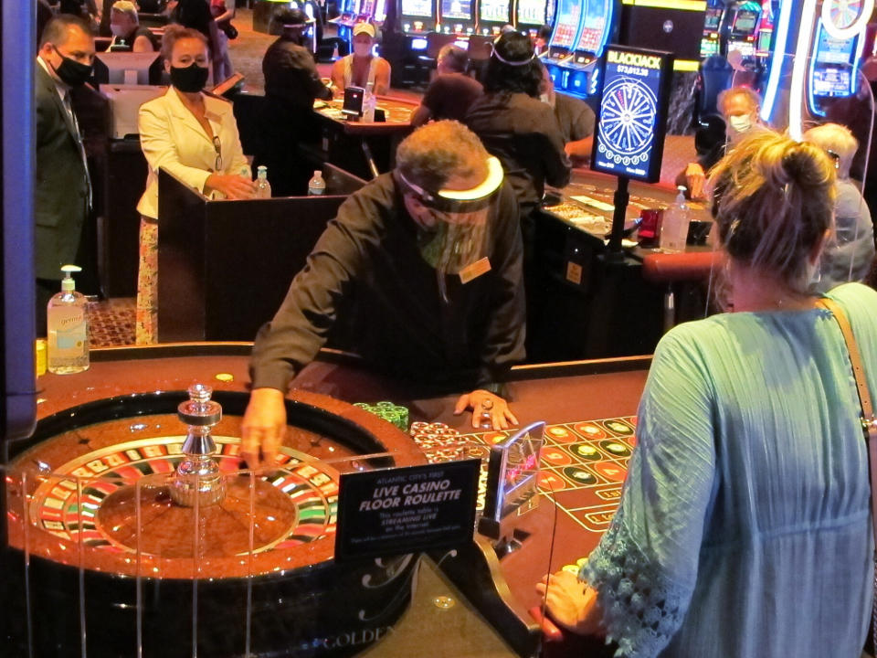 Wearing a face shield to guard against the coronavirus, a dealer conducts a roulette game at the Golden Nugget casino in Atlantic City, N.J. on July 2, 2020. The U.S. gambling industry was a big winner at the polls on Nov. 3, 2020, with three states authorizing sports betting and three others either authorizing or expanding casino gambling. Maryland, South Dakota and Louisiana approved sports betting. (AP Photo/Wayne Parry)