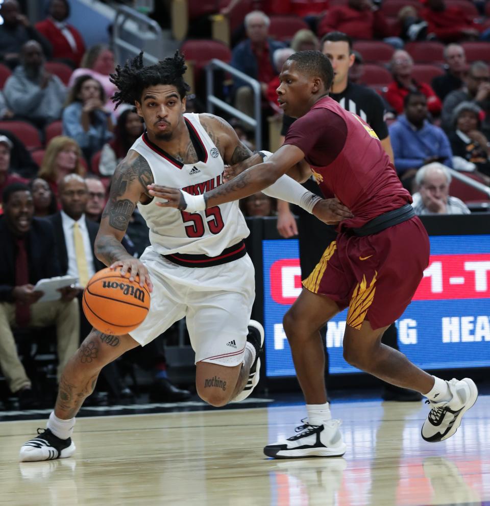 U of L's Skyy Clark drives against Simmons College's Kevin Bland. Clark tallied eight points and six assists Wednesday night.