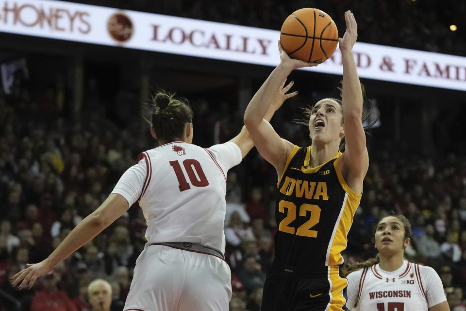 Iowa's Caitlin Clark shoots past Wisconsin's Halle Douglass during the first half of a women's NCAA college basketball game Sunday, Dec. 10, 2023, in Madison, Wis. (AP Photo/Morry Gash)