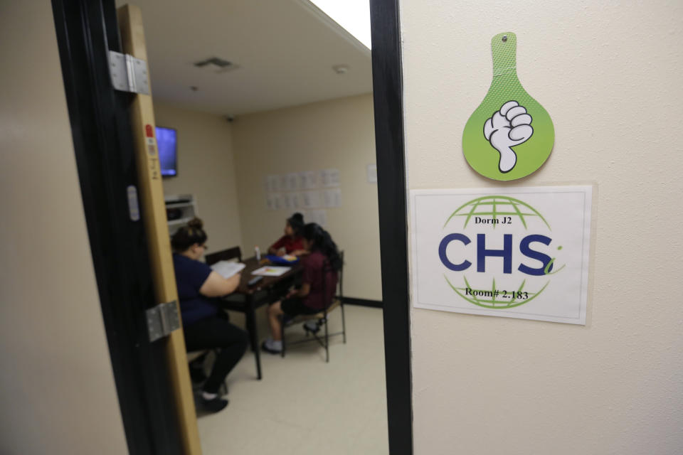 Migrant teens a work in their dorm room at a Comprehensive Health Services "tender-age" facility, a facility for babies, children and teens, in Texas' Rio Grande Valley, Thursday, Aug. 29, 2019, in San Benito, Texas. Sheltering migrant children has become a booming business for Comprehensive Health Services, a Florida-based government contractor, as the number of children in government custody has swollen to record levels over the past two years. (AP Photo/Eric Gay)