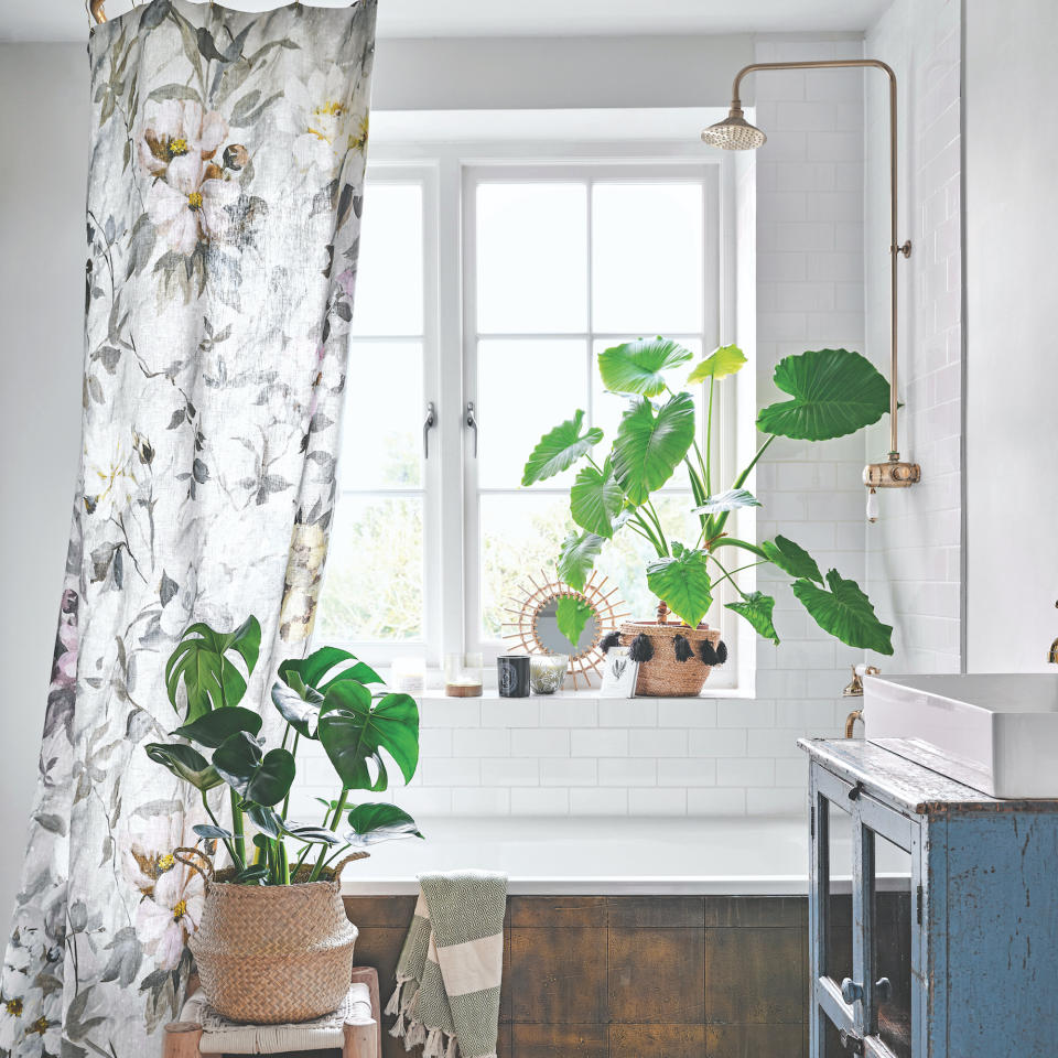 white bathroom with black and white floral shower curtain above a bath