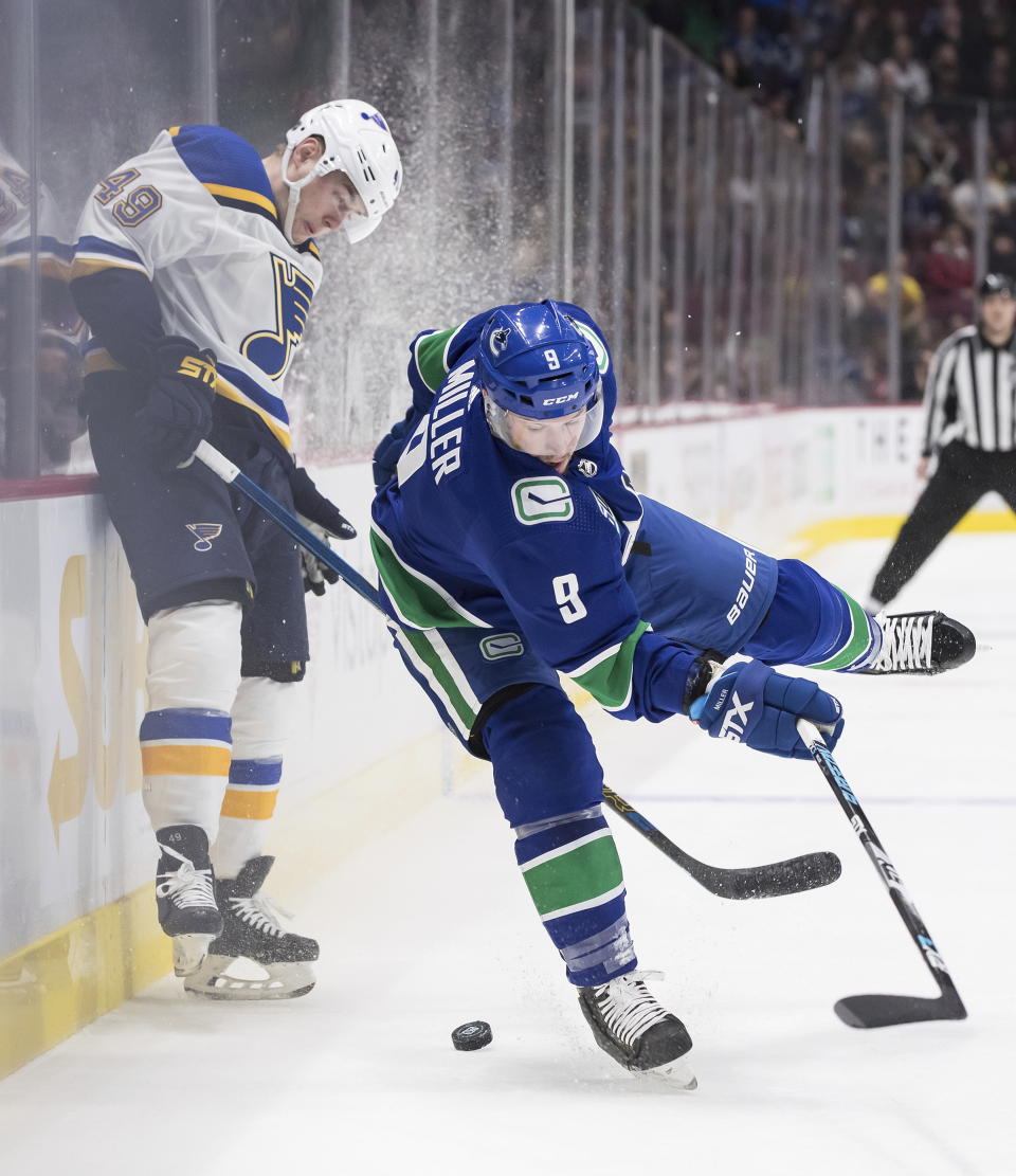 Vancouver Canucks' J.T. Miller, right, loses his footing while vying for the puck against St. Louis Blues' Ivan Barbashev, of Russia, during the first period of an NHL hockey game in Vancouver, British Columbia on Monday Jan. 27, 2020. (Darryl Dyck/The Canadian Press via AP)