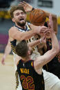 Indiana Pacers' Domantas Sabonis (11) loses control of the ball as Cleveland Cavaliers' Dean Wade (32) defends during the second half of an NBA basketball game Wednesday, March 3, 2021, in Cleveland. (AP Photo/Tony Dejak)