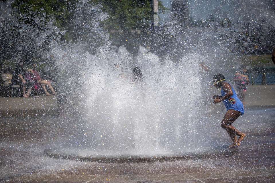 While Portland reached a record temperature of over 110 degrees Sunday, June 27, 2021 people gathered at Salmon Street Springs water fountain in Portland to cool off. (Mark Graves/The Oregonian via AP)