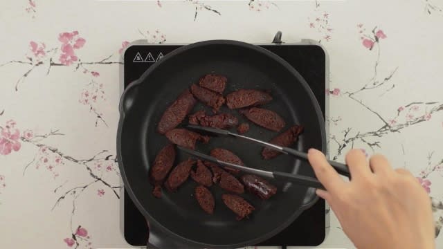 Dry frying chopped duck liver sausage on frying pan