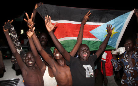 South Sudanese civilians display their national flag as they celebrate the signing of a cease fire and power sharing agreement between President Salva Kiir and rebel leader Riek Machar, in Khartoum; along the streets of Juba, South Sudan August 5, 2018. REUTERS/Samir Bol