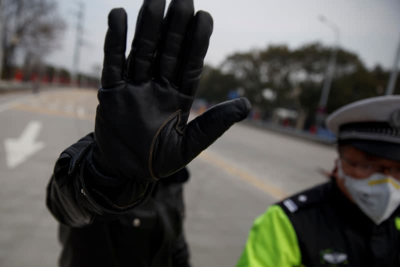 A police officer attempts to prevent the photographer from taking pictures at a checkpoint at the Jiujiang Yangtze River Bridge in Jiujiang