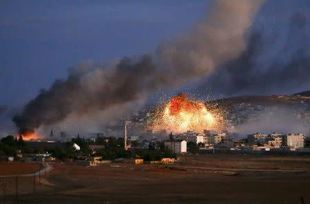 Smoke and flames rise over Syrian town of Kobani after an airstrike, as seen from the Mursitpinar crossing on the Turkish-Syrian border in the southeastern town of Suruc in Sanliurfa province, October 20, 2014. REUTERS/Kai Pfaffenbach