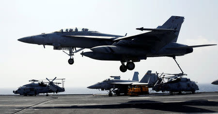 A U.S. Navy F18 fighter jet lands on the deck of aircraft carrier USS Carl Vinson. REUTERS/Erik De Castro