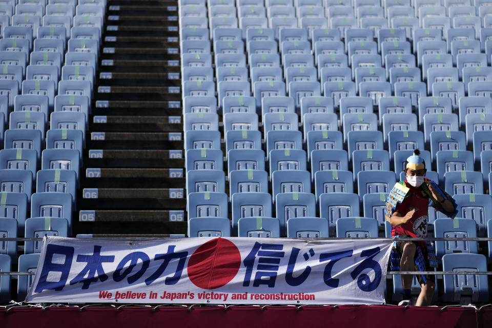 A fan poses for poses for a picture as he arrives at Miyagi Stadium for a women's soccer match at the 2020 Summer Olympics, Saturday, July 24, 2021, in Miyagi, Japan. (AP Photo/Andre Penner)