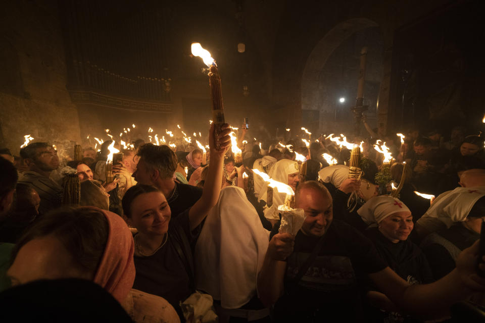 A Christian Orthodox pilgrim holds up a candle during the Holy Fire ceremony at the Church of the Holy Sepulchre, where many Christians believe Jesus was crucified, buried and rose from the dead, in the Old City of Jerusalem, Saturday, May 4, 2024. In the annual ceremony that has been observed for over a millennium, a flame taken from Jesus' tomb is used to light the candles of fervent believers of Christian Orthodox communities near and far. The devout believe the origin of the flame is a miracle and is shrouded in mystery. (AP Photo/Leo Correa)